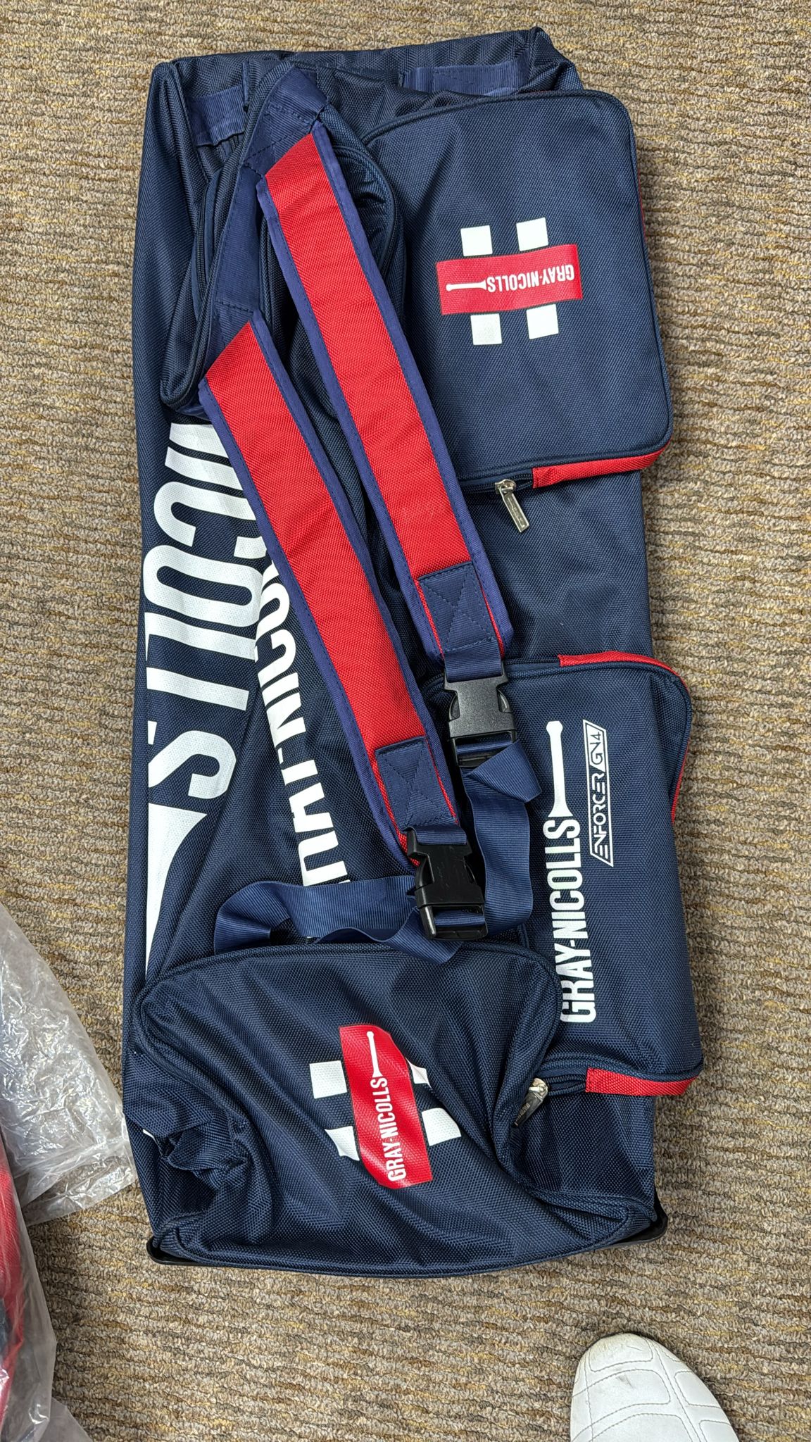 Navy and red sports bag with visible branding on a textured surface